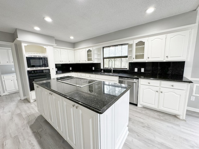 kitchen featuring a kitchen island, white cabinetry, sink, and stainless steel appliances