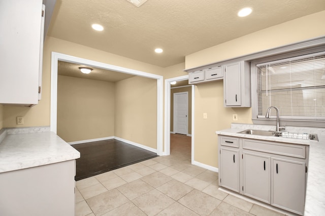 kitchen featuring sink, light tile patterned floors, and a textured ceiling