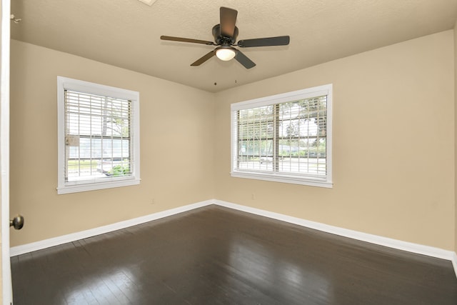 spare room with ceiling fan, a healthy amount of sunlight, wood-type flooring, and a textured ceiling