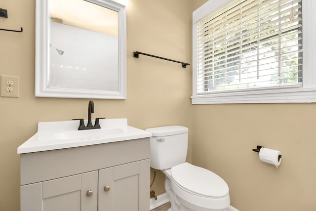 bathroom with a wealth of natural light, vanity, and toilet