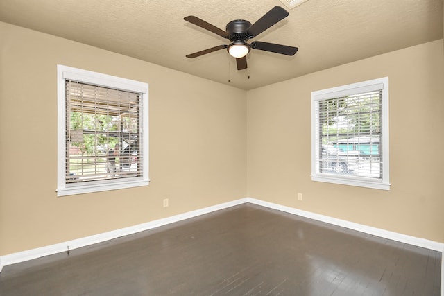 unfurnished room featuring a textured ceiling, dark wood-type flooring, ceiling fan, and a healthy amount of sunlight