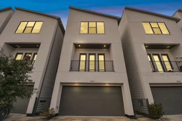 view of front facade with a garage and a balcony