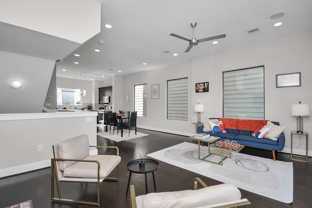 living room with dark wood-type flooring and ceiling fan