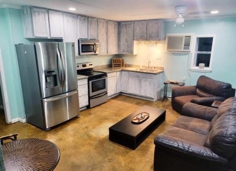 kitchen with appliances with stainless steel finishes, sink, ceiling fan, and a wall mounted air conditioner