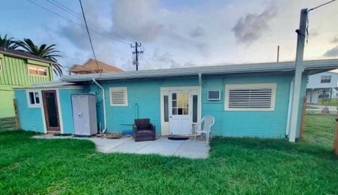 rear view of house with a yard and a patio area