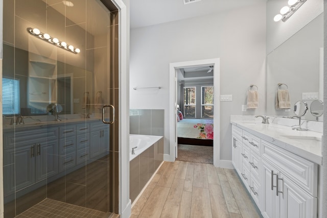 bathroom featuring independent shower and bath, vanity, hardwood / wood-style floors, and ceiling fan