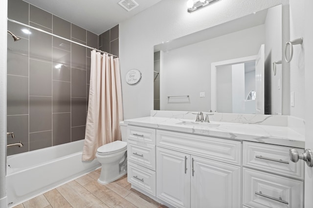 full bathroom featuring vanity, shower / bath combo with shower curtain, and toilet