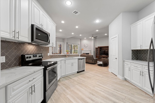 63 Shetland Ln, Coldspring, TX 77331 - kitchen with stainless steel appliances, ceiling fan, a sink, open floor plan, and white cabinets