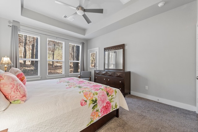 bedroom with a tray ceiling, carpet flooring, and ceiling fan