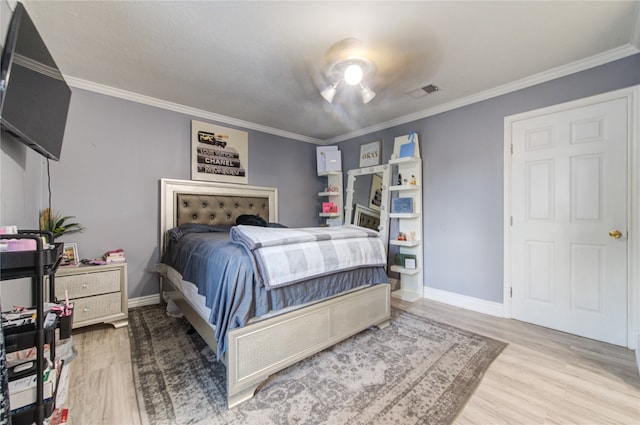 bedroom featuring light wood-type flooring and crown molding