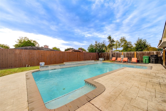 view of pool featuring pool water feature and a patio