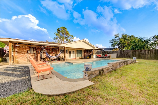 view of swimming pool with a patio area and a yard