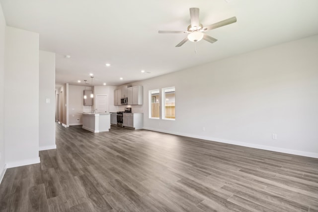 unfurnished living room featuring ceiling fan, dark wood-type flooring, recessed lighting, and baseboards