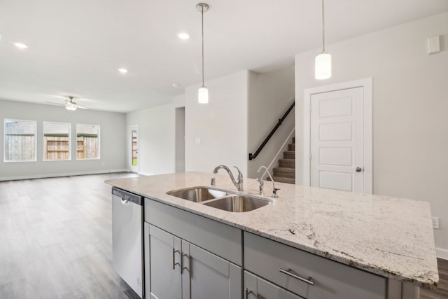 kitchen with a sink, open floor plan, gray cabinets, dishwasher, and an island with sink