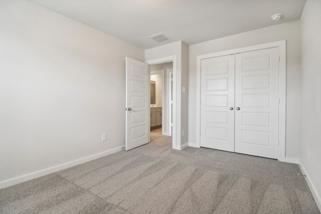 unfurnished bedroom featuring carpet, a closet, visible vents, and baseboards