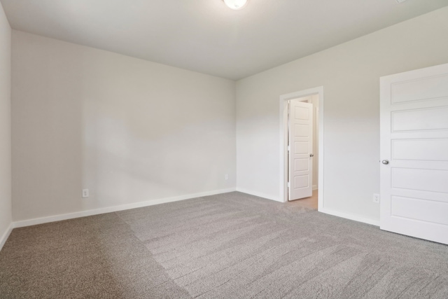 unfurnished room with carpet floors and baseboards