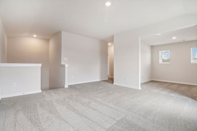 carpeted spare room featuring vaulted ceiling, baseboards, and recessed lighting