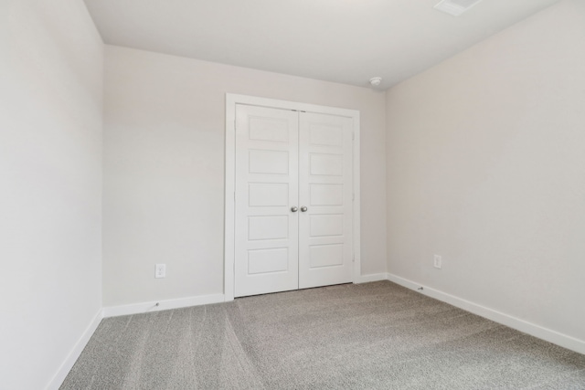 unfurnished bedroom featuring carpet floors, a closet, and baseboards