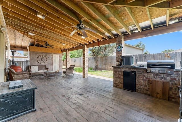 view of patio / terrace with an outdoor kitchen, area for grilling, ceiling fan, and a deck