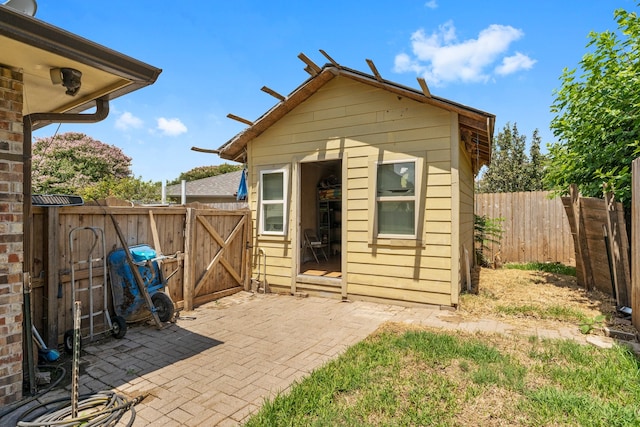 back of house with an outdoor structure and a patio area