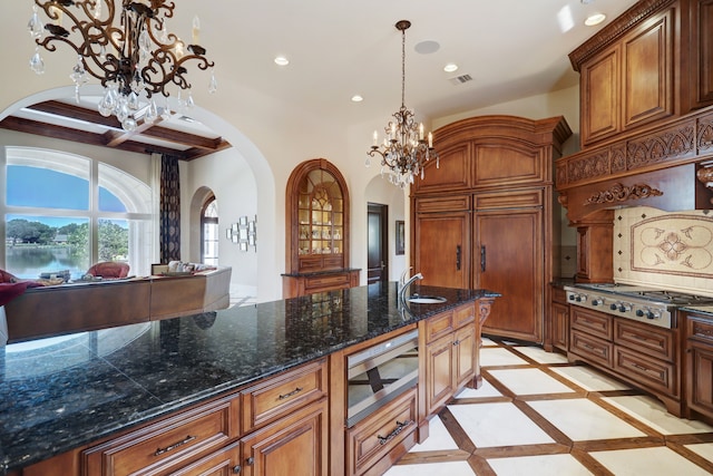 kitchen with stainless steel gas cooktop, a notable chandelier, sink, tasteful backsplash, and pendant lighting