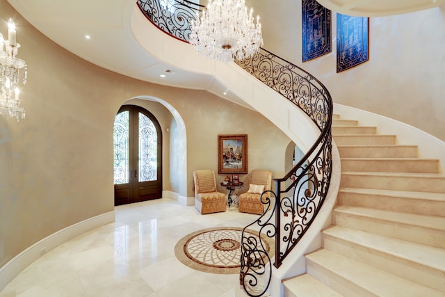 foyer entrance with an inviting chandelier and french doors