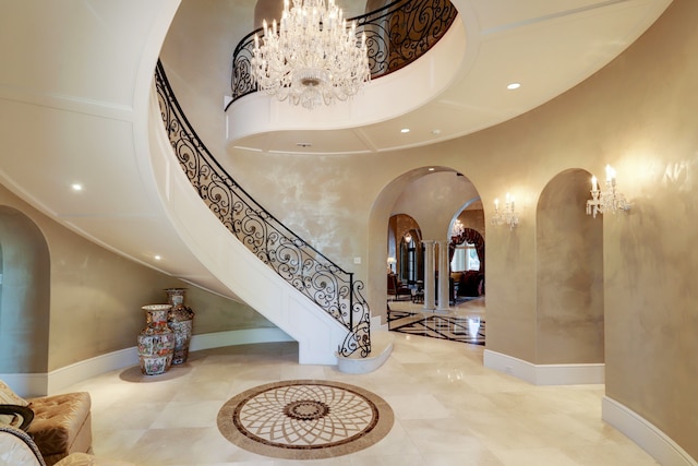 foyer featuring a towering ceiling and an inviting chandelier