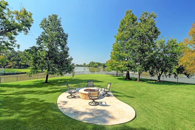 view of yard featuring a patio area, a water view, and a fire pit