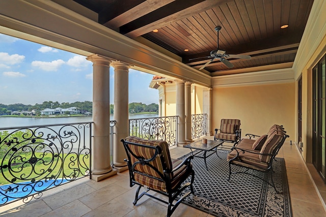 balcony with ceiling fan and a water view