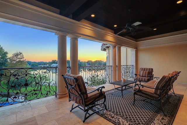 balcony at dusk featuring ceiling fan