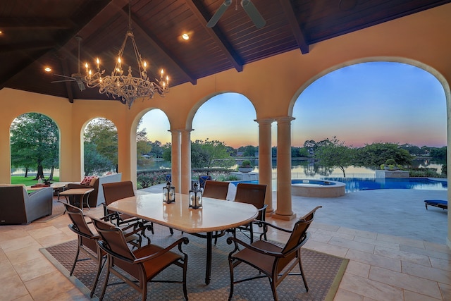 patio terrace at dusk with a swimming pool with hot tub and ceiling fan