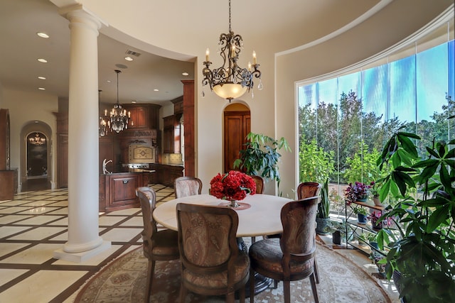 dining area with a notable chandelier and decorative columns