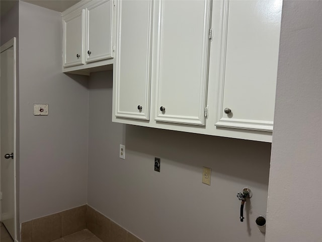 clothes washing area featuring electric dryer hookup, cabinets, tile patterned flooring, gas dryer hookup, and hookup for a washing machine