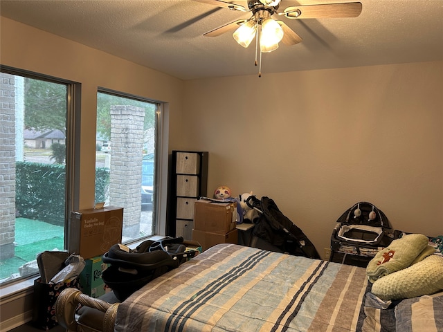 bedroom featuring a textured ceiling, multiple windows, and ceiling fan