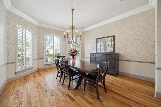 dining room with light hardwood / wood-style flooring, ornamental molding, and a chandelier