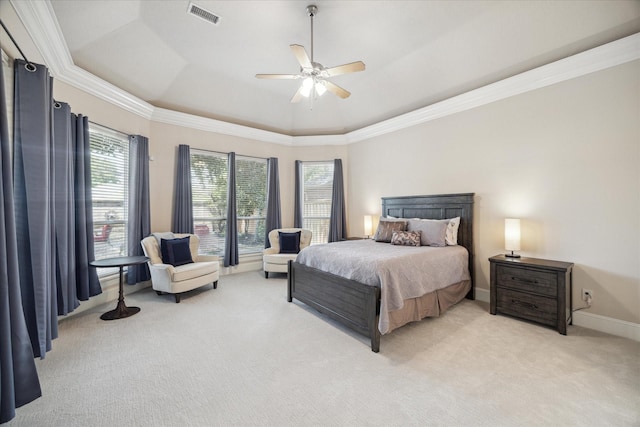 carpeted bedroom featuring a tray ceiling, ornamental molding, and ceiling fan