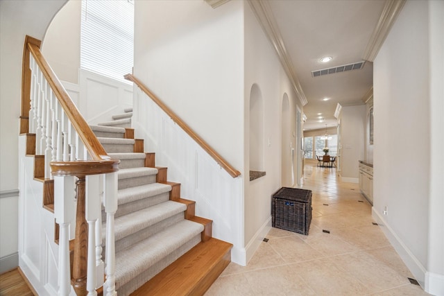 stairs featuring tile patterned floors and ornamental molding