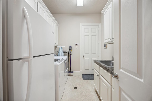 laundry area featuring light tile patterned flooring, washer / clothes dryer, sink, and a textured ceiling