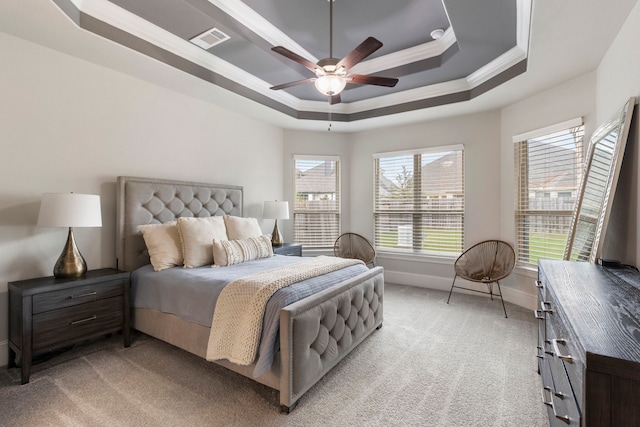 bedroom featuring ceiling fan, light carpet, crown molding, and a tray ceiling