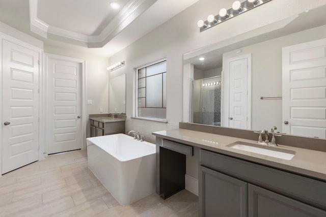 bathroom featuring vanity, shower with separate bathtub, crown molding, and a tray ceiling