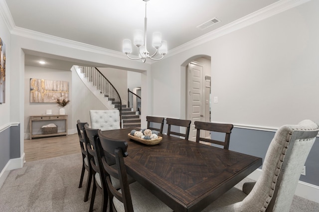 dining area with an inviting chandelier, light carpet, and crown molding