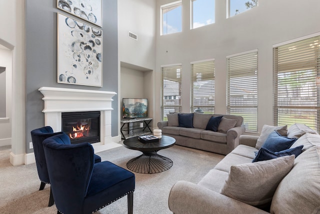 living room featuring a high ceiling and light colored carpet