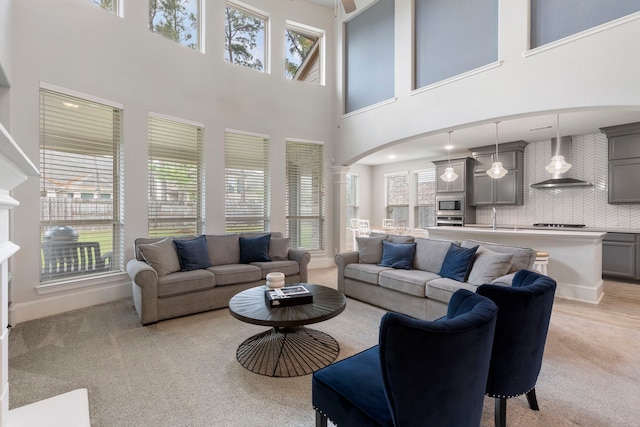 carpeted living room with a towering ceiling and a wealth of natural light