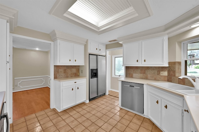 kitchen with white cabinets, appliances with stainless steel finishes, sink, and backsplash