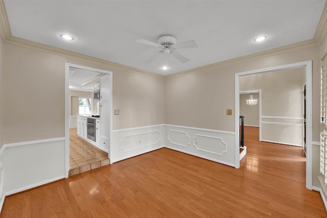 unfurnished room featuring ornamental molding, ceiling fan, and light hardwood / wood-style floors