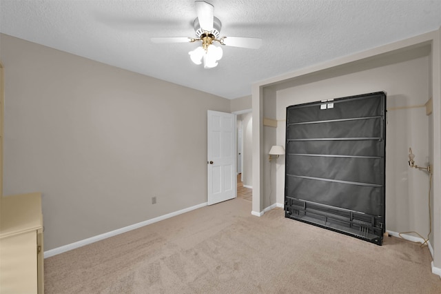 unfurnished bedroom with ceiling fan, a textured ceiling, and carpet floors