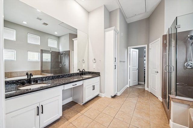 bathroom with vanity, a towering ceiling, a shower with door, and tile patterned floors