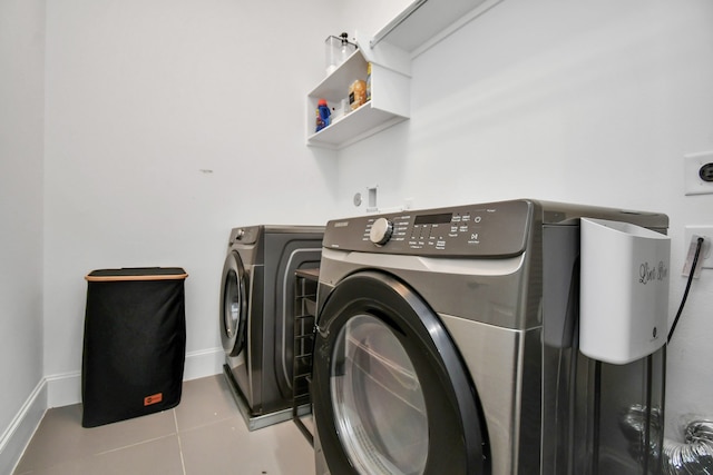 laundry room featuring washer and clothes dryer and light tile patterned flooring