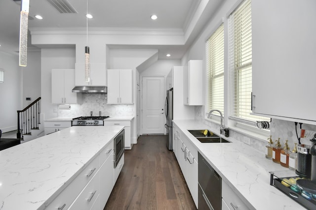 kitchen featuring stainless steel appliances, white cabinetry, dark hardwood / wood-style floors, hanging light fixtures, and sink