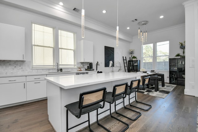 kitchen with white cabinets, dark hardwood / wood-style floors, decorative light fixtures, and a center island